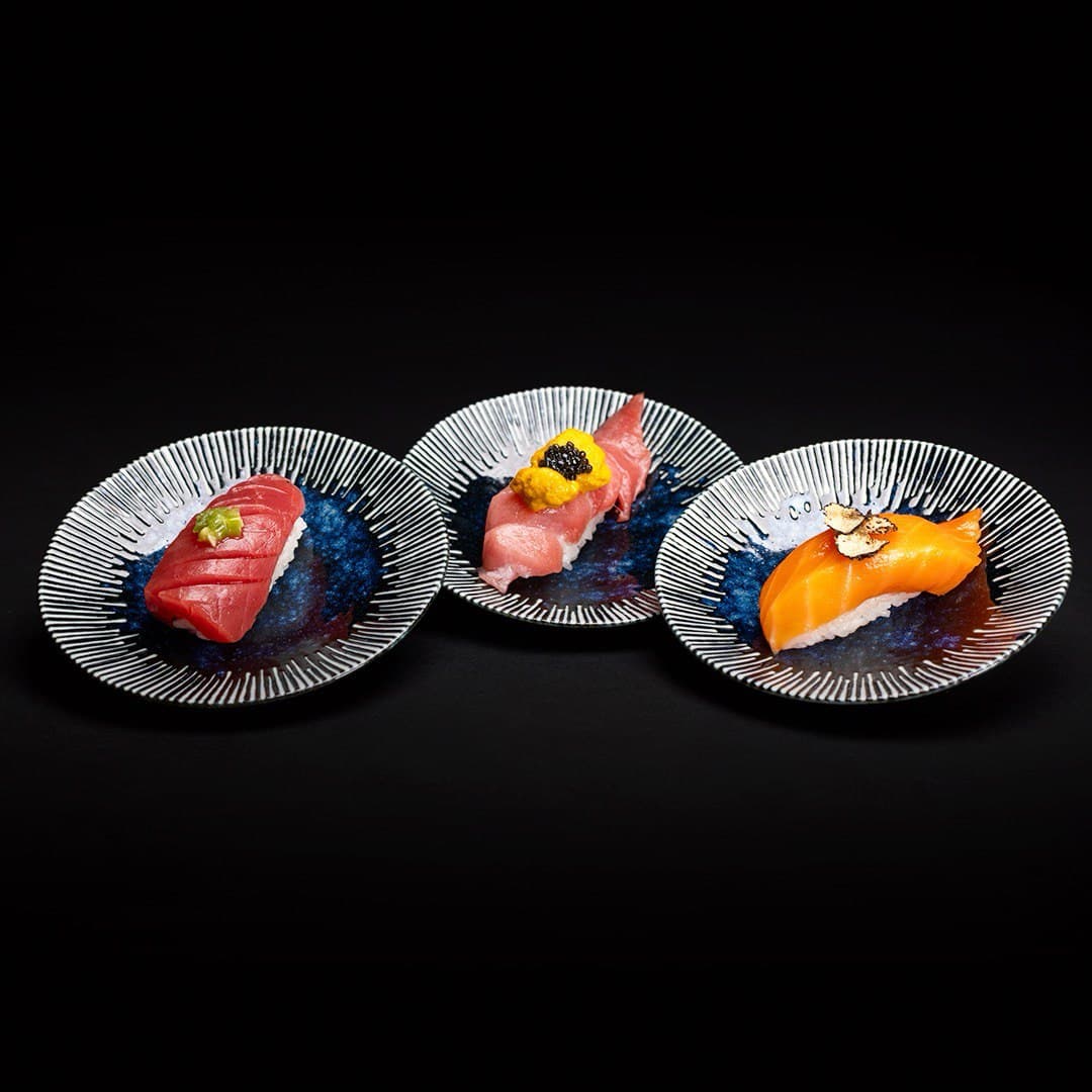 Chef tasting nigiri flight with caviar and gold leaf