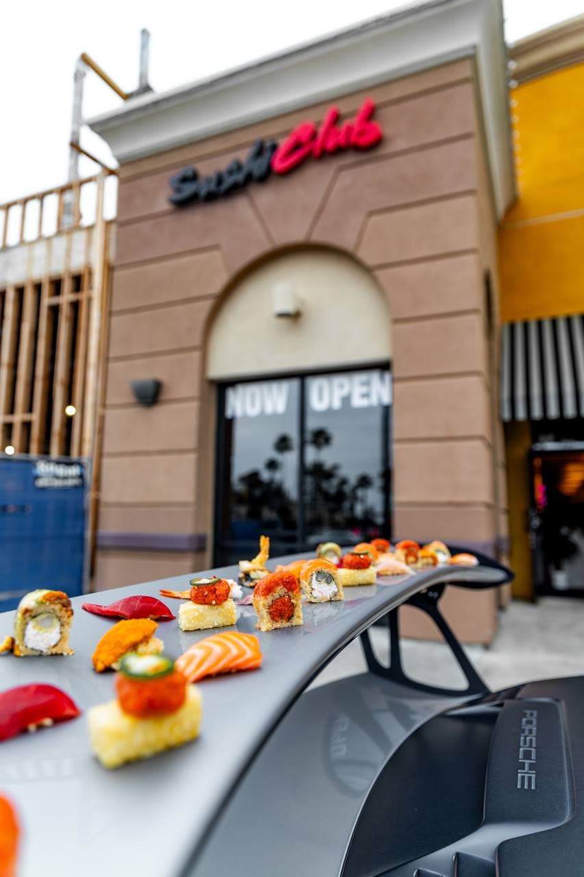Sushi Club front entrance with glass doors under an arched facade