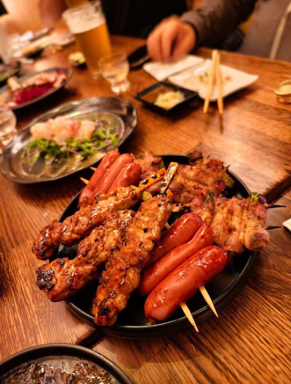 Sushi Club Izakaya dinner table feast with skewers, craft beer and sake